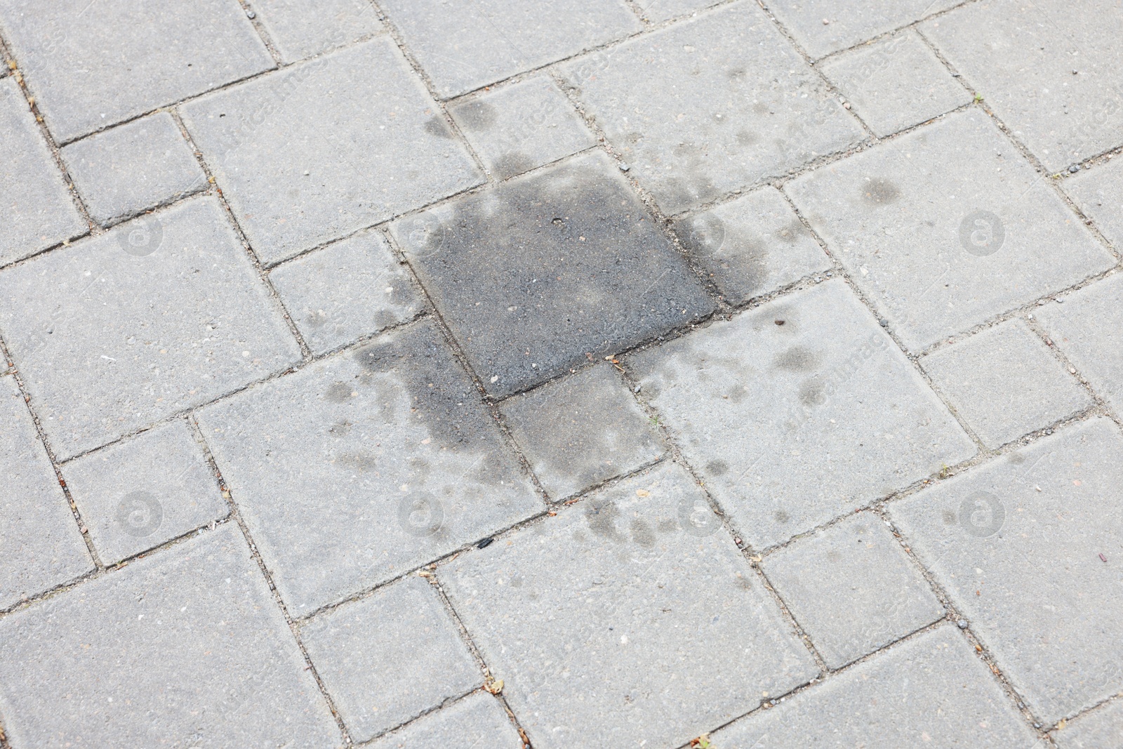 Stains of motor oil on road outdoors, closeup Photo of Stains of motor oil on road outdoors, closeup
