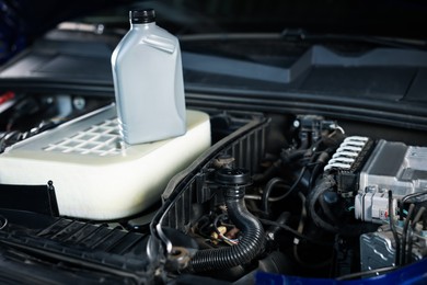 Photo of Bottle of motor oil on car engine, closeup