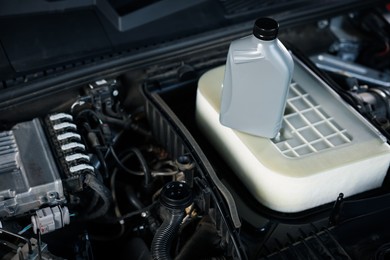 Photo of Bottle of motor oil on car engine, closeup