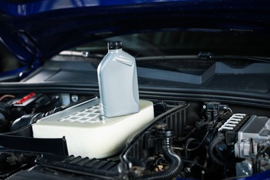 Photo of Bottle of motor oil on car engine, closeup