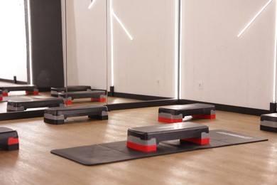 Photo of Many step platforms in fitness studio. Sports equipment