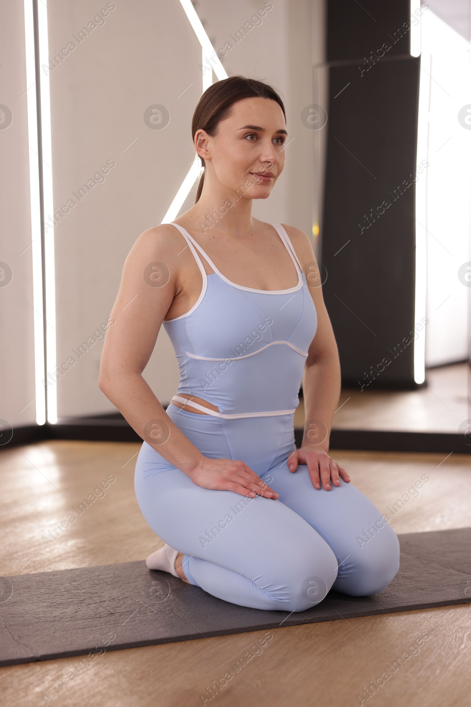 Photo of Woman wearing sportswear on mat in fitness studio