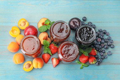 Photo of Different jams in jars and ingredients on blue wooden table, flat lay