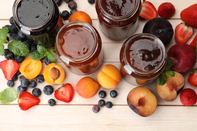Photo of Different jams in jars and ingredients on white wooden table, flat lay