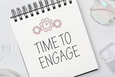 Image of Time to engage. Words and drawings in notebook on light table, top view