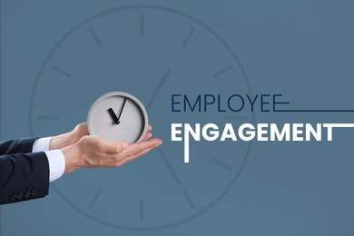 Image of Employee engagement. Businessman holding alarm clock on color background, closeup