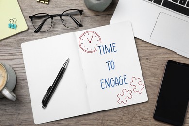 Image of Time to engage. Words and drawings in notebook on office desk, top view