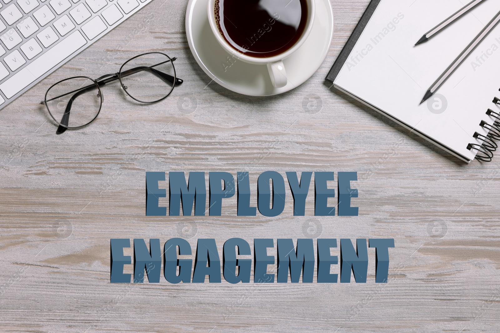 Employee engagement. Office workplace with coffee, stationery and computer keyboard on wooden table. top view Image of Employee engagement. Office workplace with coffee, stationery and computer keyboard on wooden table. top view
