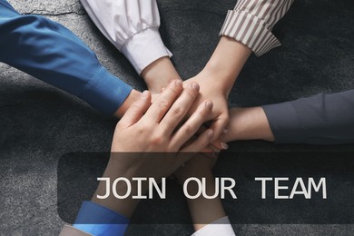 Image of Join Our Team. Group of people holding hands together at grey table, top view. Employee search, recruitment concept