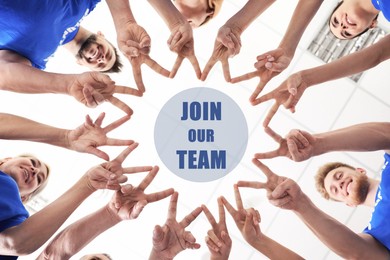 Image of Join Our Team. People showing V-sign and joining their fingers together indoors, bottom view. Employee search, recruitment concept