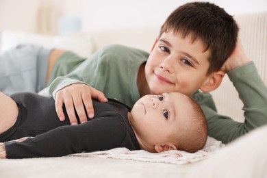 Photo of Cute little brothers on sofa at home