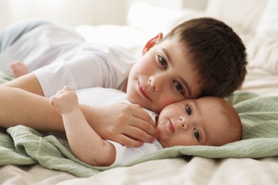 Photo of Cute little brothers on bed at home