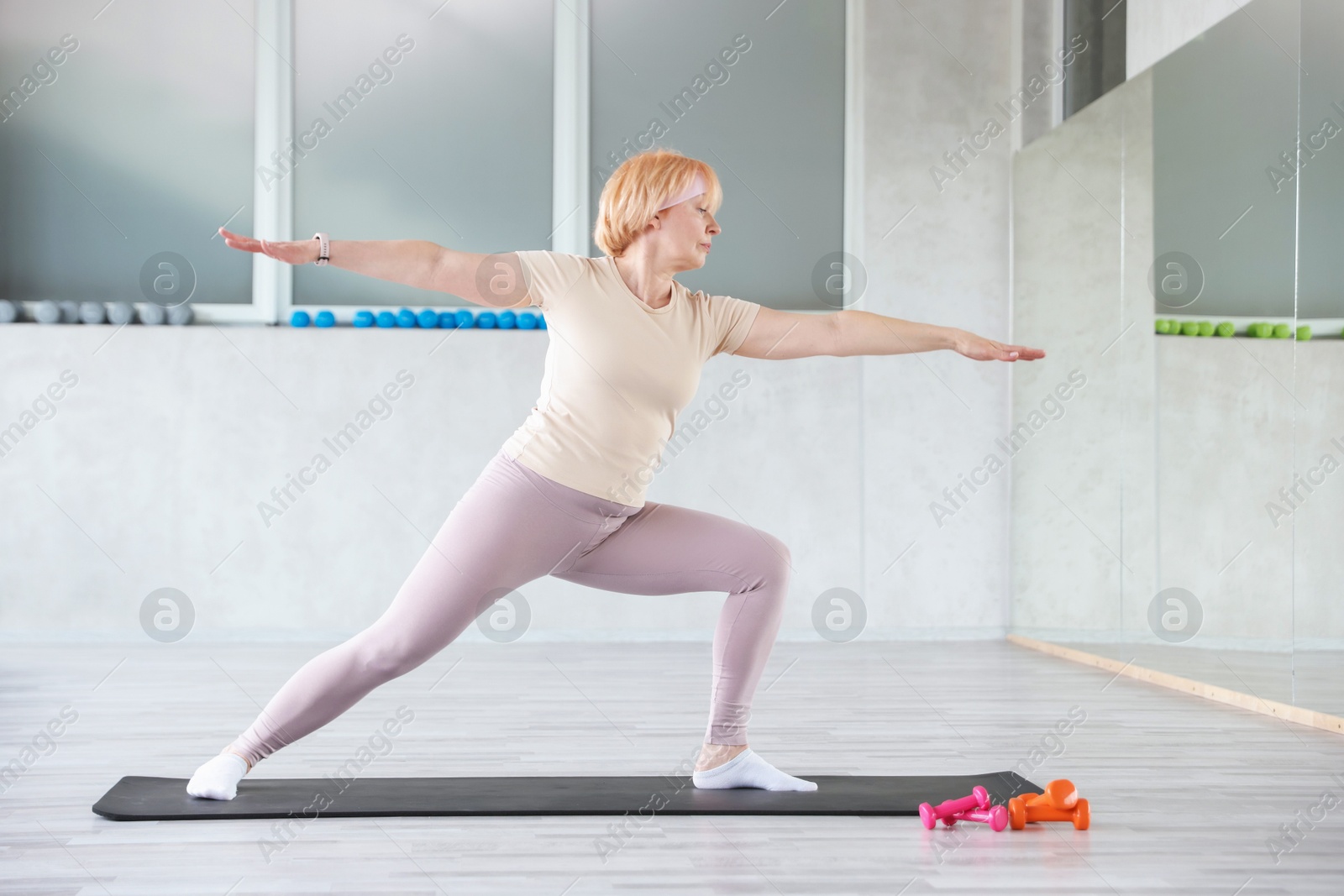 Senior woman exercising on fitness mat in gym Photo of Senior woman exercising on fitness mat in gym