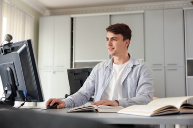 Photo of Man working on computer at desk in public library