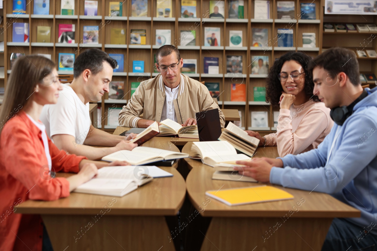 Photo of People studying together at desks in public library