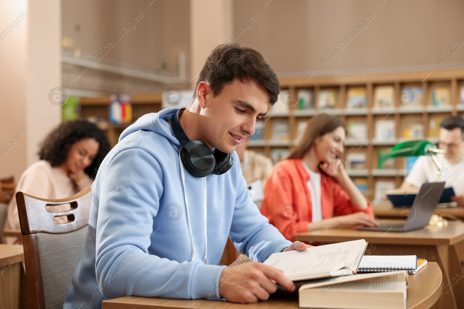 Photo of People studying at desks in public library, selective focus