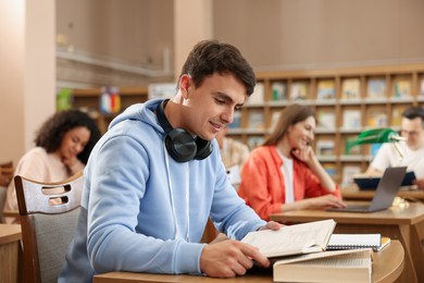 Photo of People studying at desks in public library, selective focus