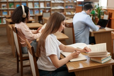 Photo of People studying at desks in public library, selective focus