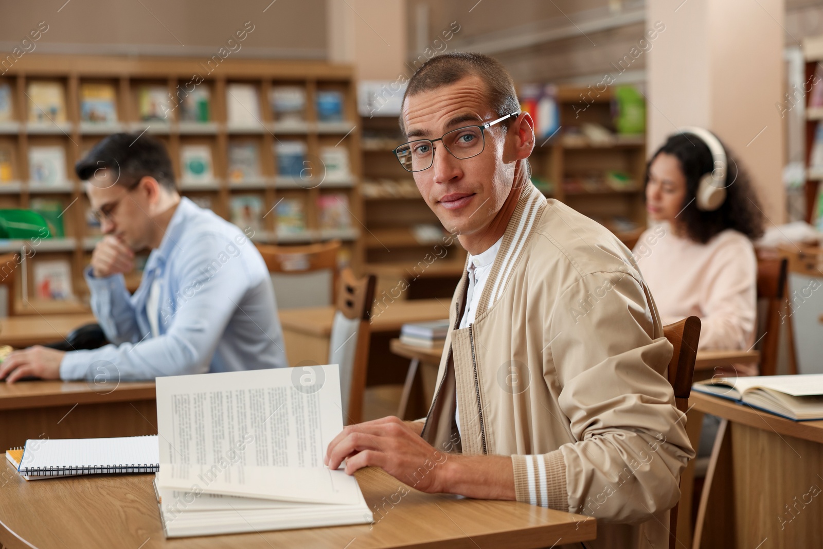 People studying at desks in public library, selective focus Photo of People studying at desks in public library, selective focus