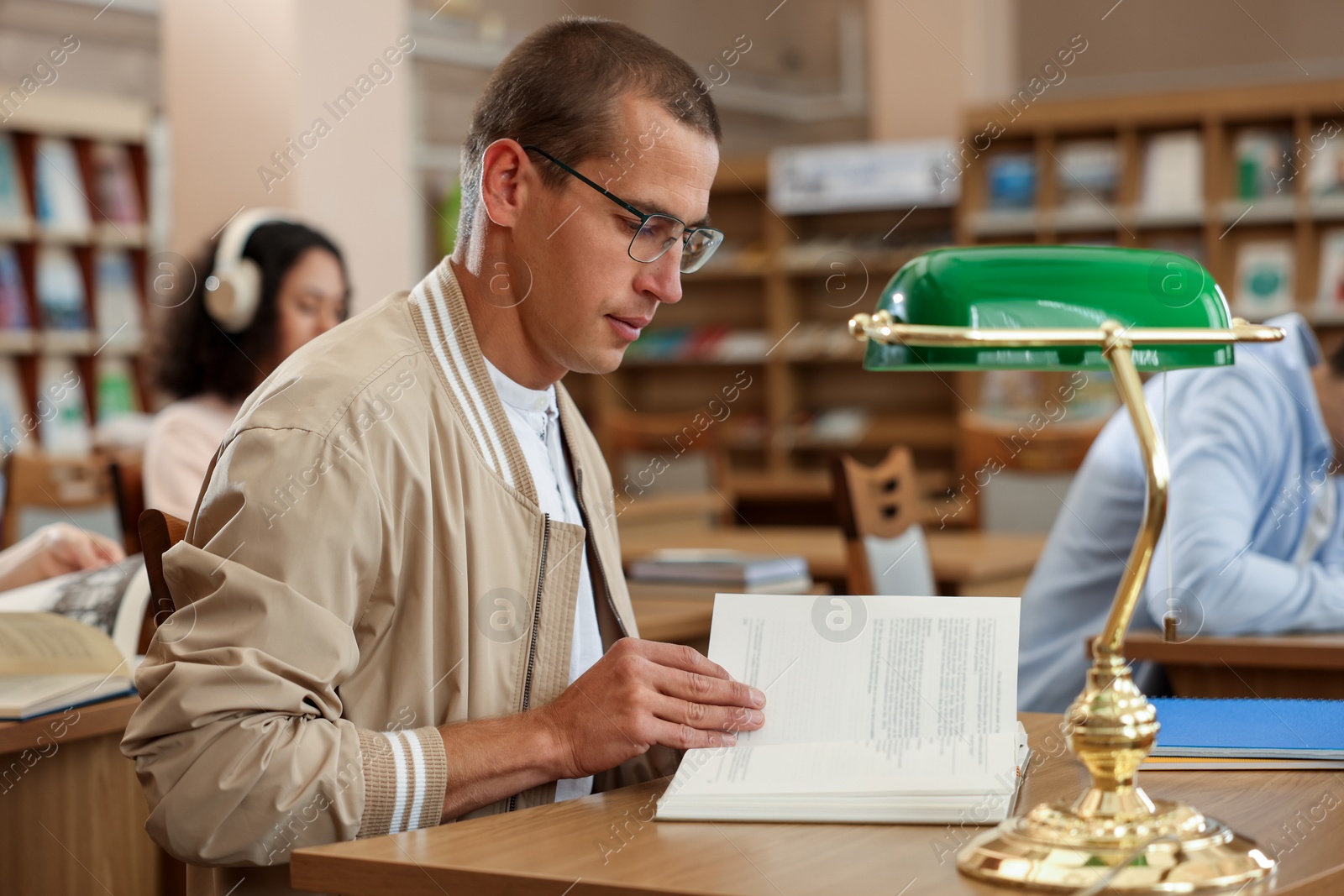 Photo of People studying at desks in public library, selective focus