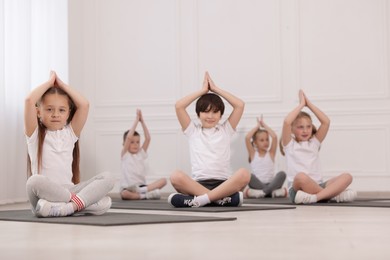 Photo of Group of children practicing yoga on mats in class