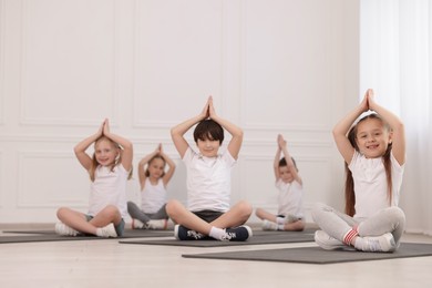 Photo of Group of children practicing yoga on mats in class