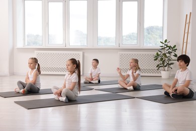 Photo of Group of children practicing yoga on mats in class