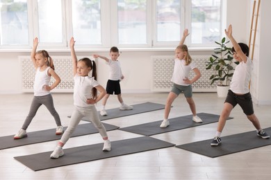 Photo of Group of children practicing yoga on mats in class
