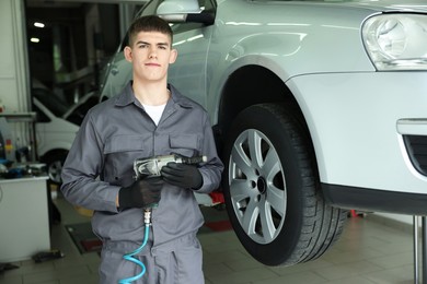 Photo of Professional mechanic changing tire at car service