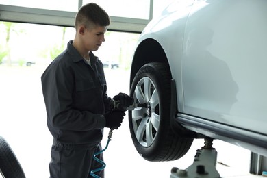 Photo of Professional mechanic changing tire at car service