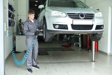 Photo of Professional mechanic changing tire at car service