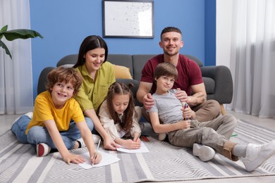 Photo of Parents teaching their kids to draw on floor at home