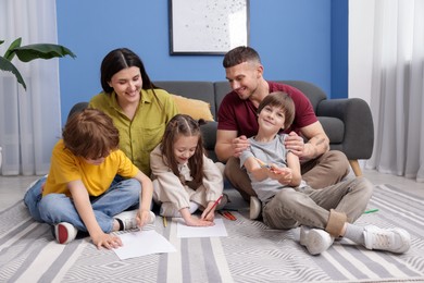 Photo of Parents teaching their kids to draw on floor at home
