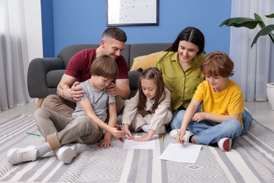 Photo of Parents teaching their kids to draw on floor at home