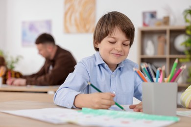 Photo of Kids with teacher at painting lesson indoors, selective focus. Learning to draw