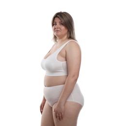 Photo of Weight loss. Plus size woman in underwear on white background