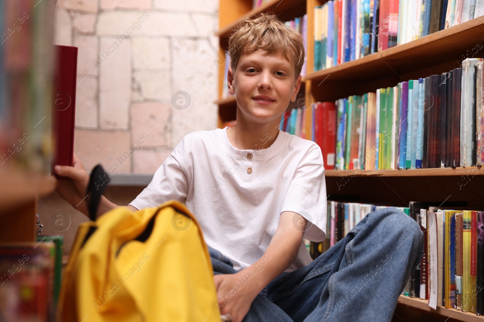 Student taking book out of shelf in library Photo of Student taking book out of shelf in library