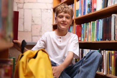 Photo of Student taking book out of shelf in library
