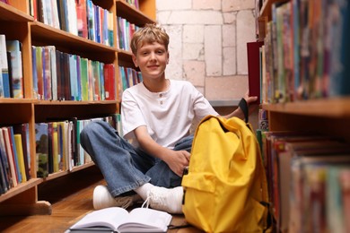 Photo of Student taking book out of shelf in library