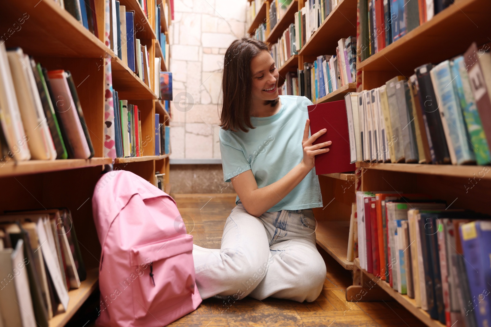Student taking book out of shelf in library Photo of Student taking book out of shelf in library