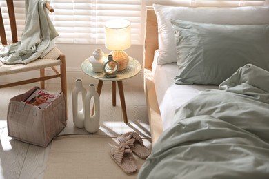 Photo of Comfortable bed with soft linens, lamp and decor in stylish room. Home textile