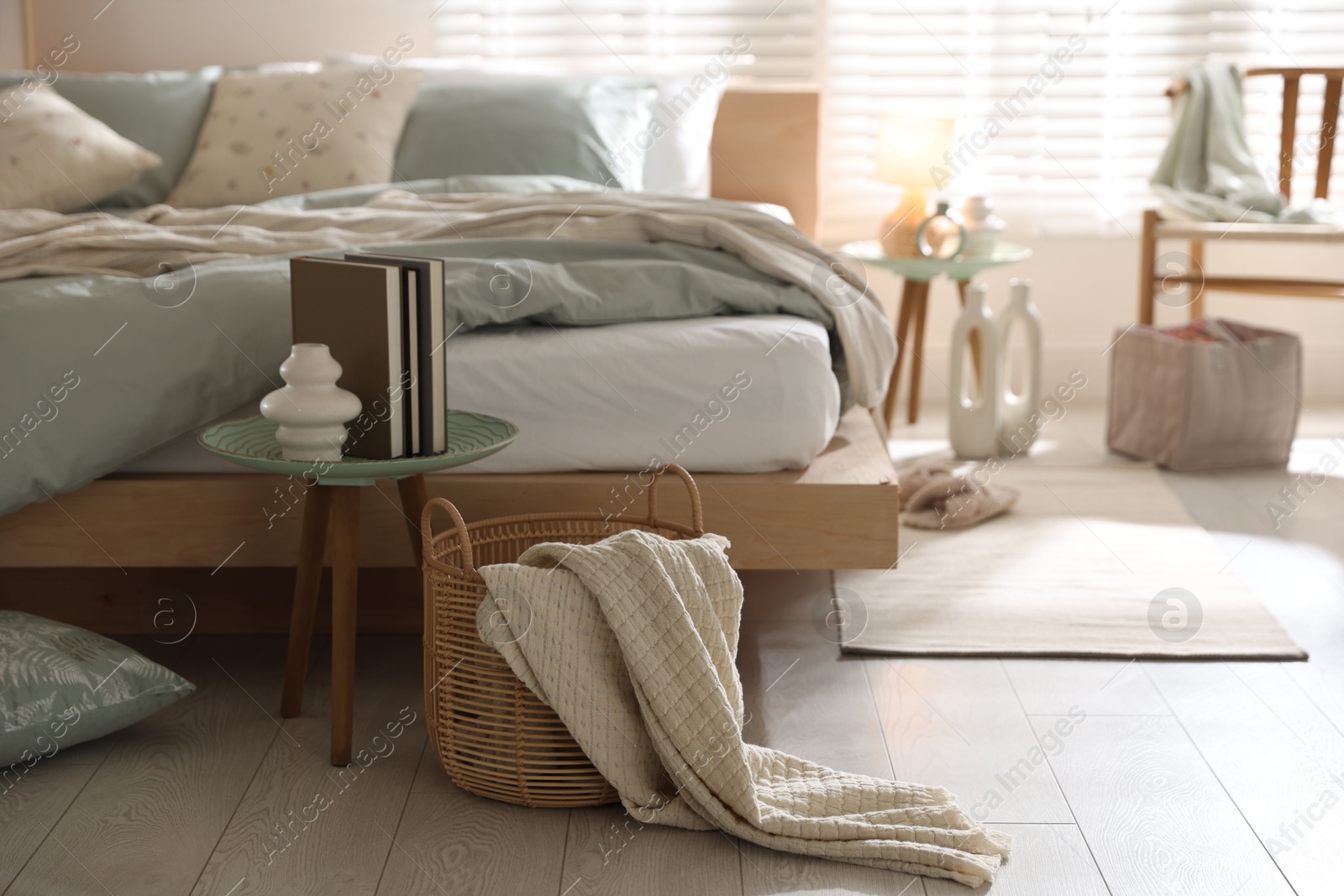 Comfortable bed with soft linens and decor in stylish room. Home textile Photo of Comfortable bed with soft linens and decor in stylish room. Home textile