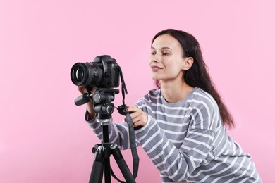 Photo of Woman with professional video camera on pink background
