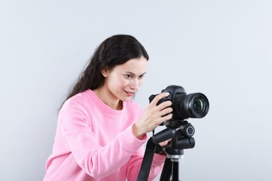 Photo of Woman with professional video camera on light grey background