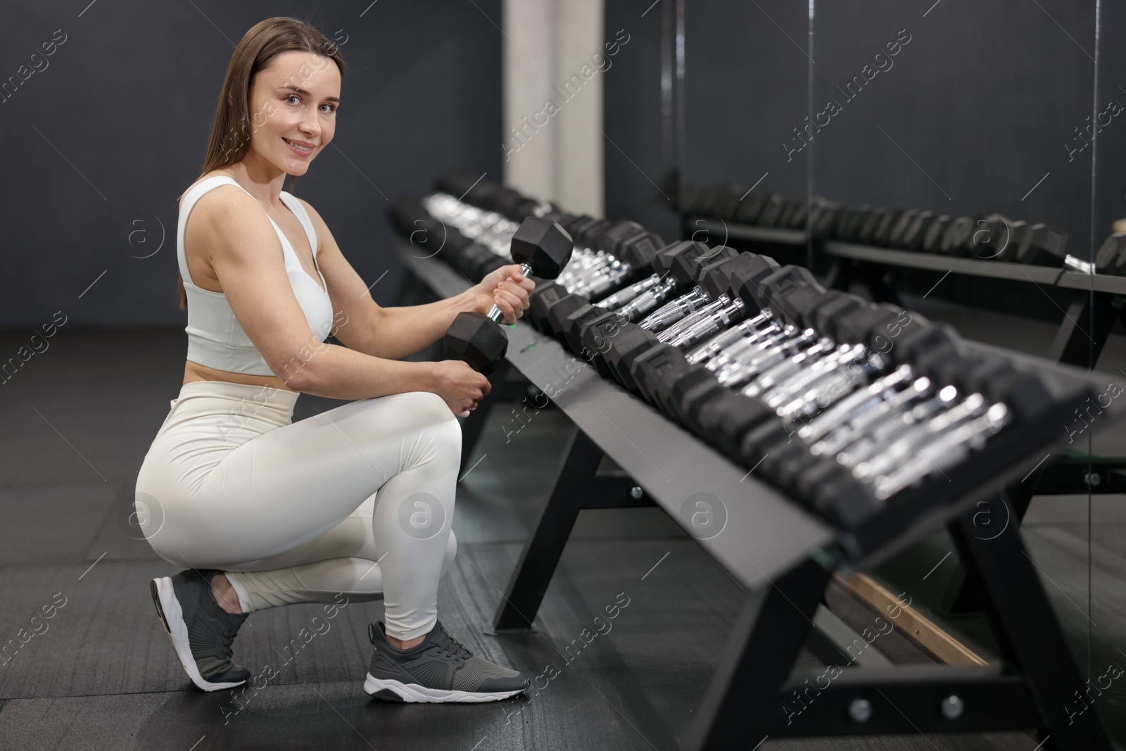 Personal trainer with dumbbells in sport center Photo of Personal trainer with dumbbells in sport center
