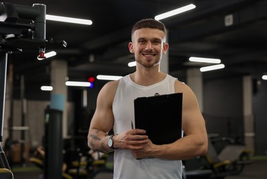 Photo of Personal trainer with clipboard in sport center