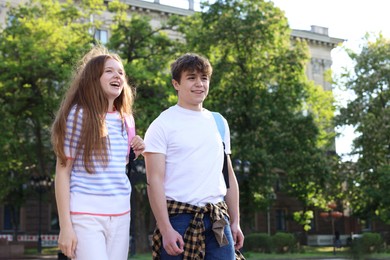 Photo of Teenage girl and boy walking together outdoors