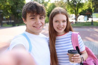 Photo of Teenage girl and boy taking selfie together in park