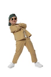 Photo of Happy little boy in sunglasses and baseball hat dancing on white background