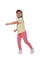 Photo of Happy little girl in baseball hat dancing on white background